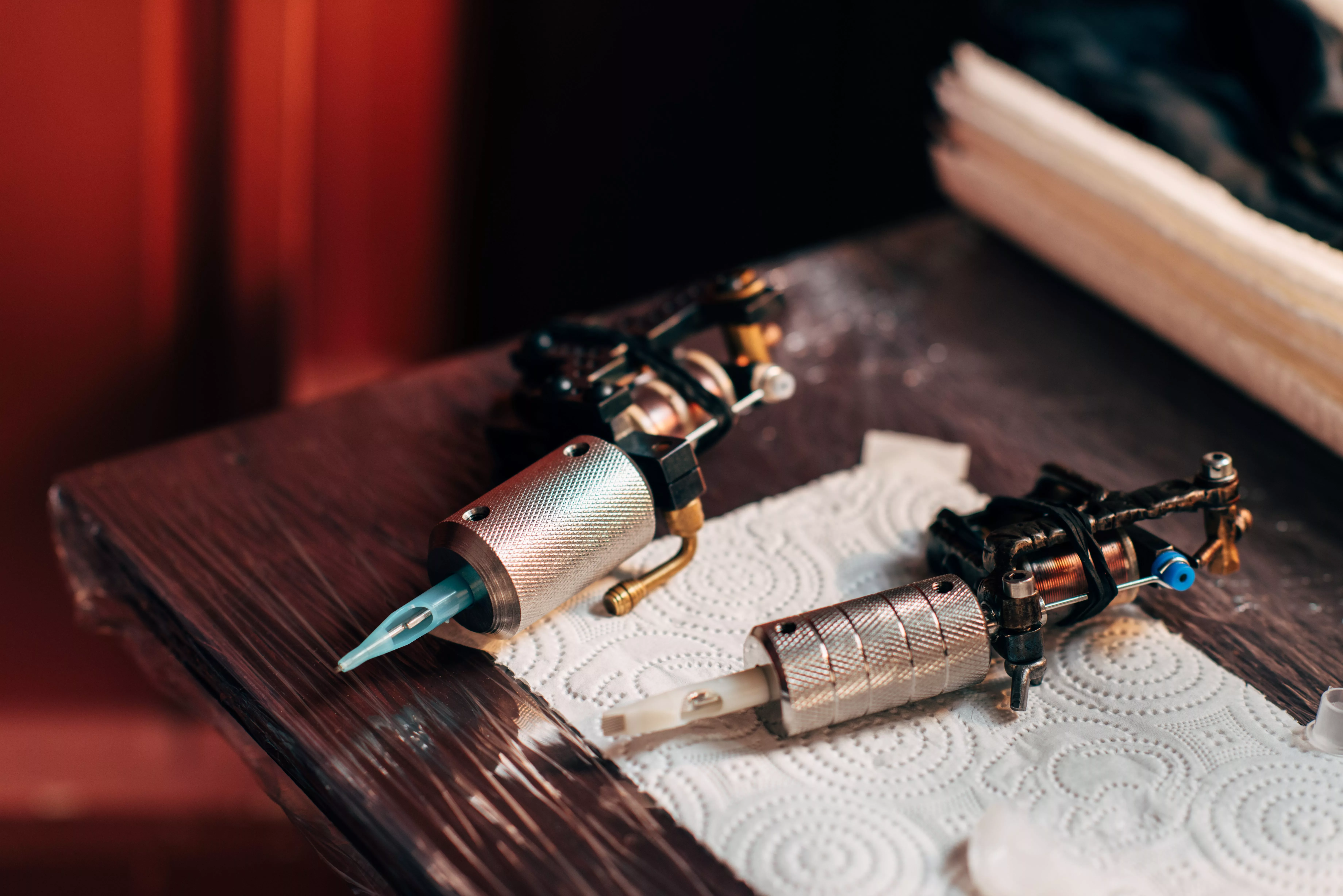 close-up-view-of-tattoo-machines-on-wooden-tabletop-at-tattoo-salon