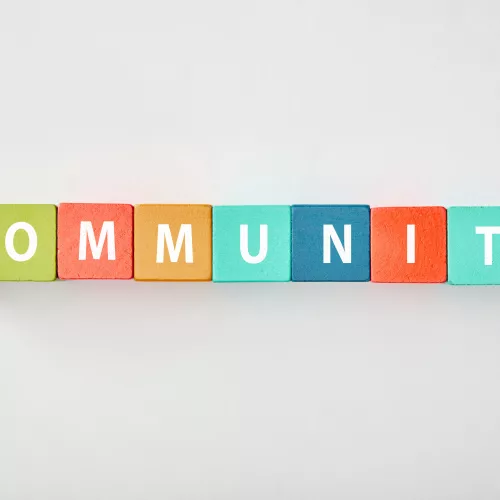top-view-of-community-lettering-made-of-multicolored-cubes-on-grey-background