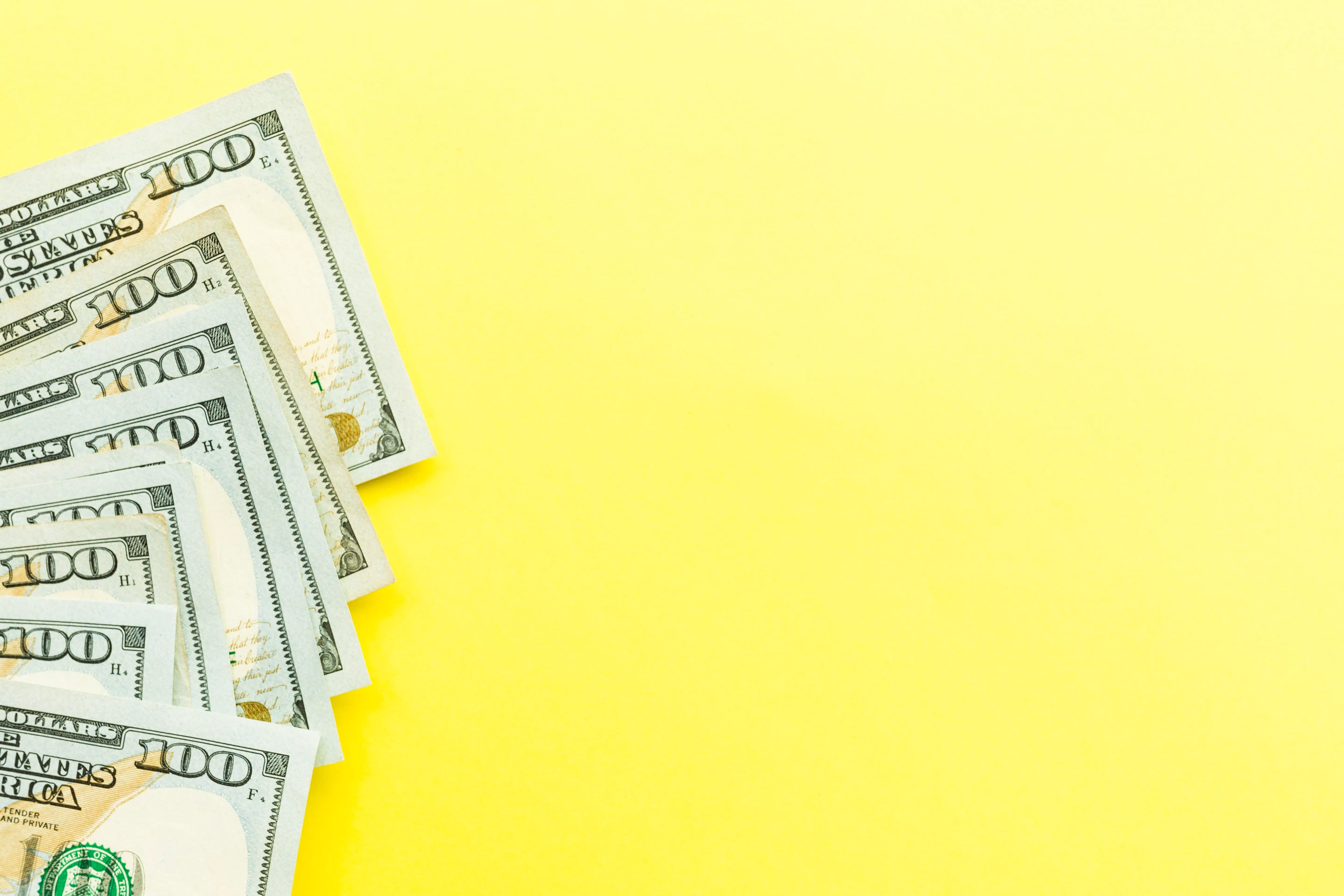 one-hundred-dollars-bill-lying-on-yellow-backgroun-2024-11-07-13-26-07-utc