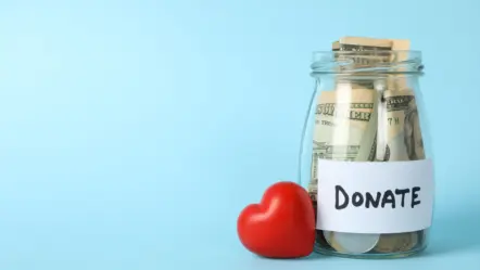 glass-jar-with-text-donate-and-heart-on-blue-background