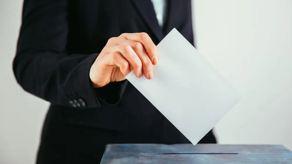 close-up-of-voter-putting-ballot-into-voting-box