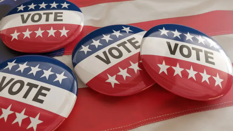 vote-on-us-america-election-text-on-pin-badges-united-states-flag-background