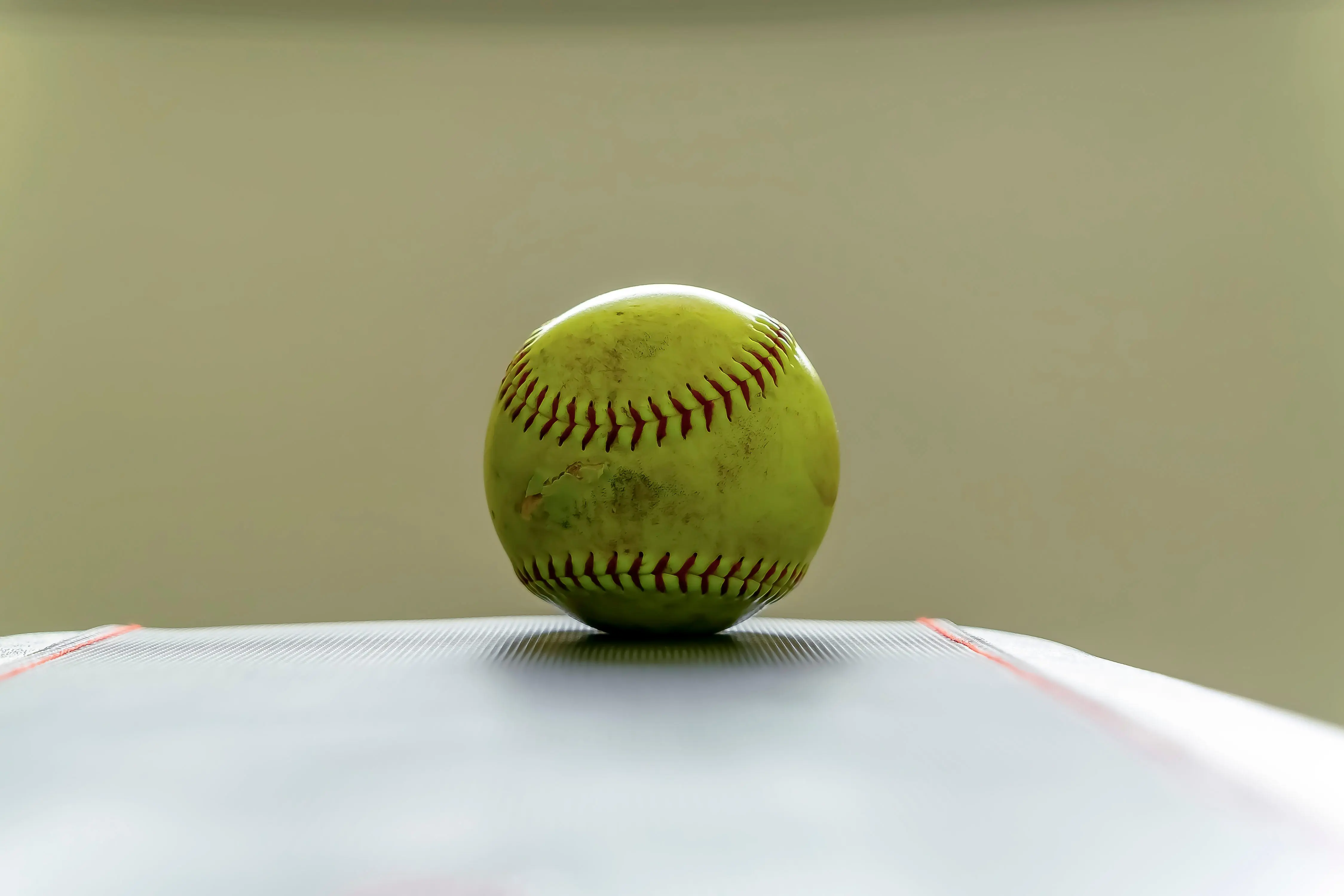 dirty-softball-on-top-of-a-white-table-and-isolate-2026-03-26-11-41-45-utc