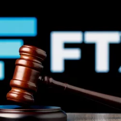 FTX is cryptocurrency exchange. Gavel on table against background of FTX logo.