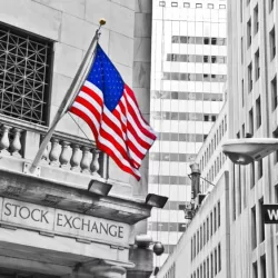 Side entrance of New York Stock Exchange and a street sign of Wall Street shown on October 11^ 2013 in New York City.