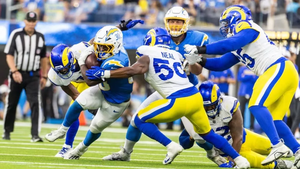 LA Chargers running back Kimani Vidal #30 runs the ball fighting off pressure from the LA Rams in an NFL football game at SoFi Stadium^ Aug. 17^ 2024^ in Inglewood^ CA.