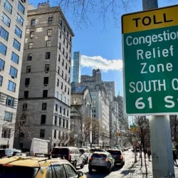 Cars driving down Fifth Avenue next to a "Toll: Congestion relief zone south of 61 Street" sign on the Upper East Side of Manhattan^ New York City New York^ NY USA - January 7^ 2025