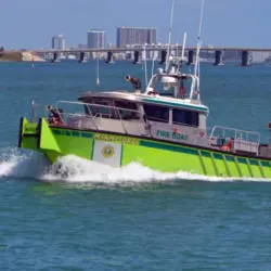 Miami-Dade fire-rescue boat patrolling on Biscayne Bay with Julia Tuttle causeway bridge in the distant background. Miami Beach^Florida^U.S.A. 13 March2021