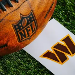 Washington Commanders NFL team Logo and American football ball on Green Grass.