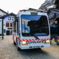 Zermatt^ Switzerland - Feb 19^ 2024 : Police vehicle in the city center of the ski resort of Zermatt in the Canton of Valais^ Switzerland - Narrow electric car Jumbolino in a car-free town of the Swis
