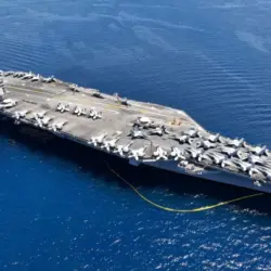 Aerial drone photo of USS Gerald R. Ford latest technology nuclear powered aircraft carrier anchored in deep blue open ocean sea