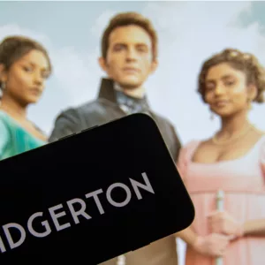 The logo of the new Netflix series "Bridgerton" on the display of a smartphone in front of the TV