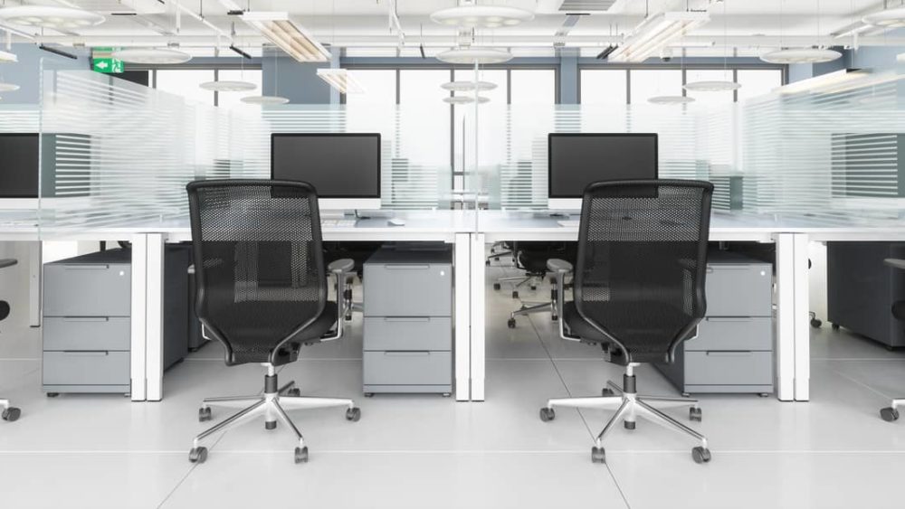 social-distancing-in-modern-office-office-desk-with-glass-partition-dividing-them