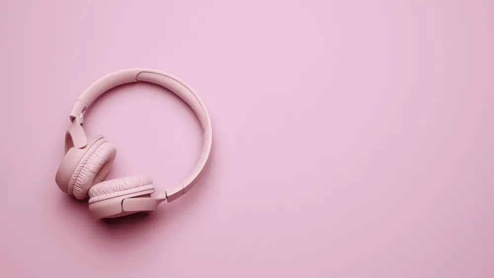 pink-wireless-headphones-on-a-pink-background-banner-top-view-on-modern-gadget