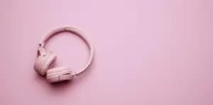 pink-wireless-headphones-on-a-pink-background-banner-top-view-on-modern-gadget