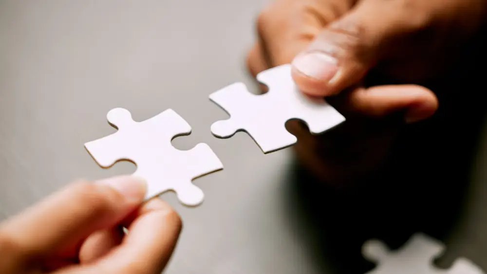 closeup-shot-of-two-unrecognizable-businesspeople-holding-puzzle-pieces-together