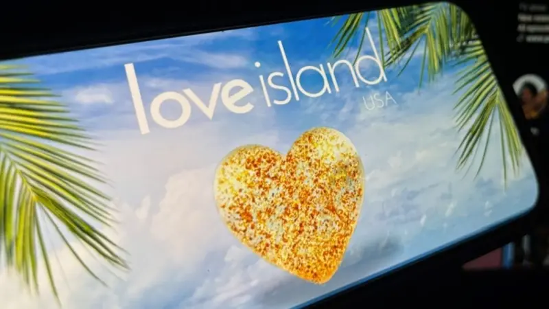 '2025 Love Island'' shown on a smart phone. is a reality dating show that originated in the UK. The premise involves a group of singles living together in a luxurious villa^ where they couple up Toronto^ Canada - June 5