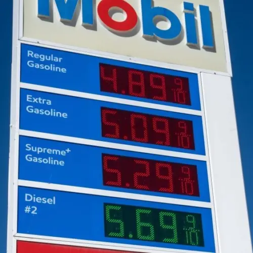 Mobil gas station sign showing high price of California Gasoline with bright blue sky Lone Pine^ CA^ USA - February 9th^ 2023