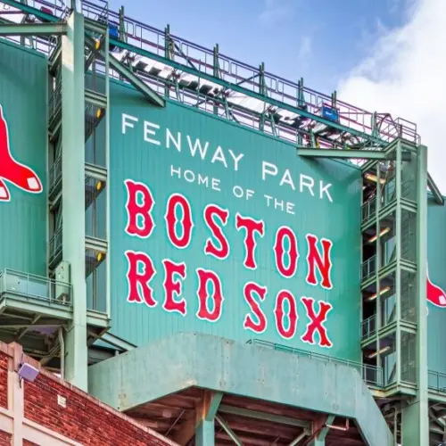 Vew of the historic architecture of the Famous Fenway Park Stadium in Boston^ MA^ USA showcasing its huge sign^ old brick walls^ and entrances on Lansdowne street. Boston^ MA^ USA - March 1^ 2023