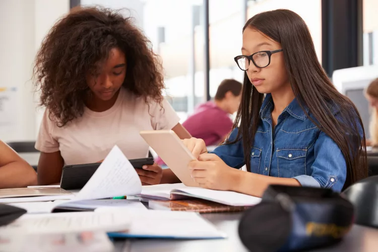 twoteenageschoolgirlsusingtabletcomputersinclass