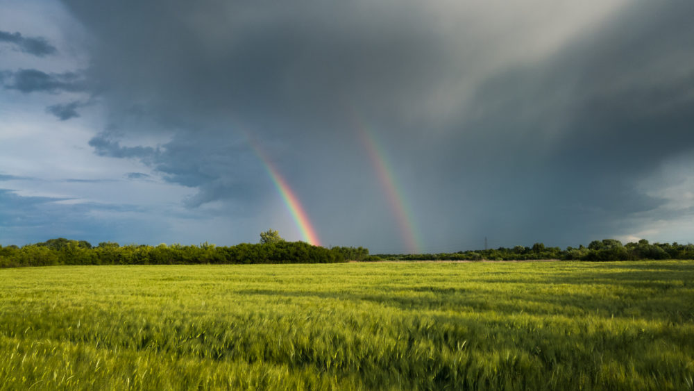doublebrightcolorfulrainbowinfrontofgloomyominousclouds