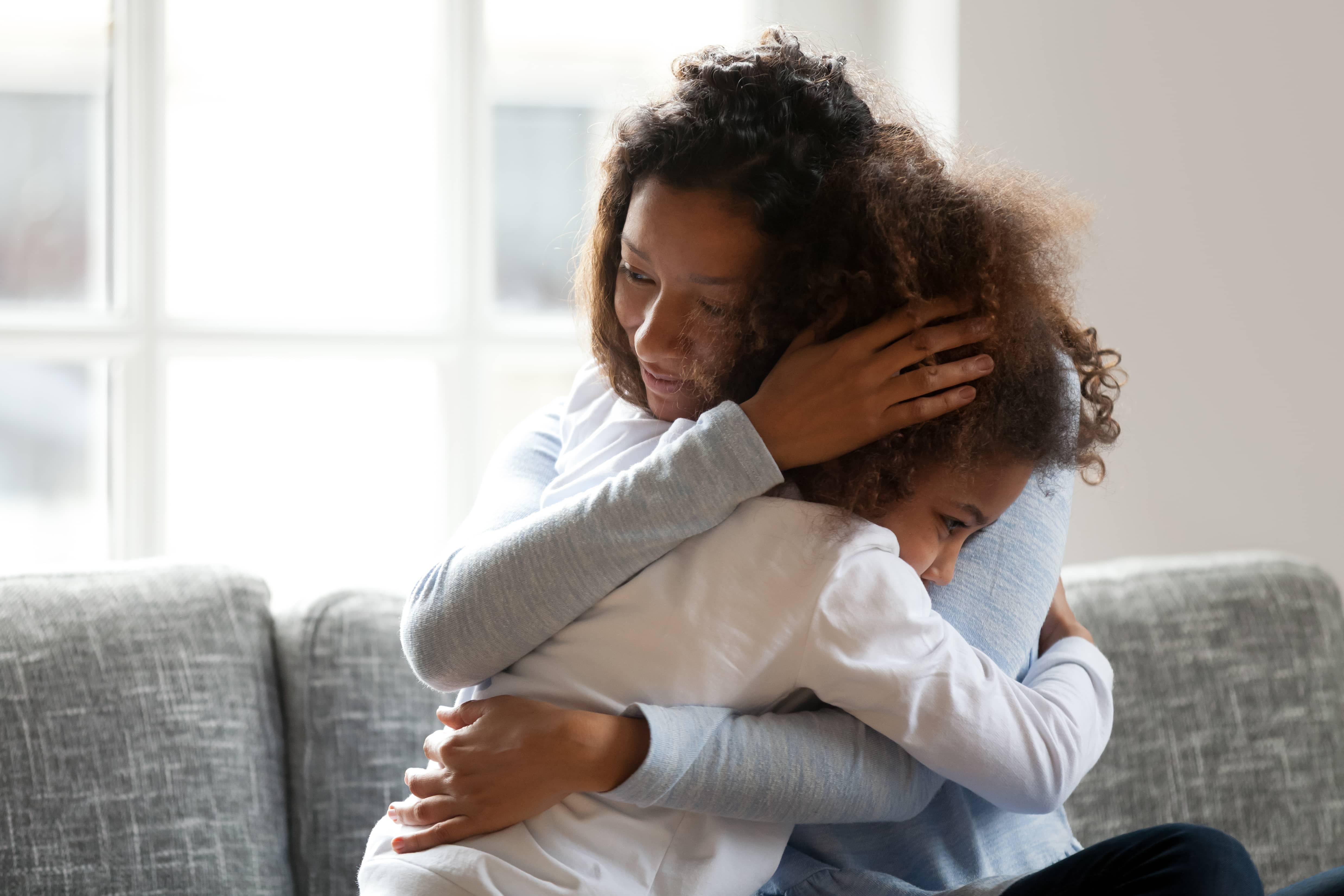 lovingsingleblackmotherhuggingafricandaughtercaressingcuddlingcaring
