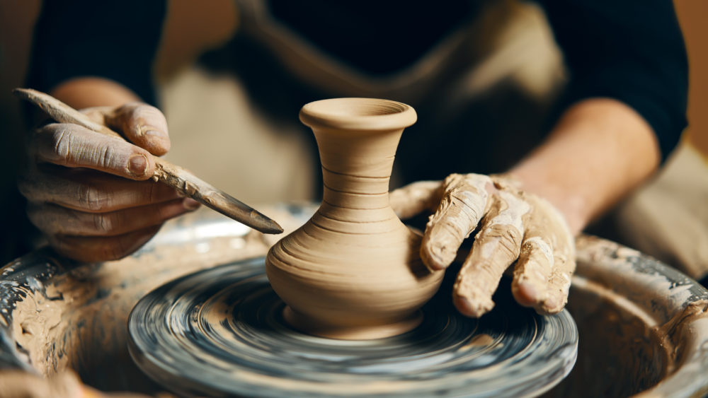manpotterworkingonpotterswheelmakingceramicpotfrom