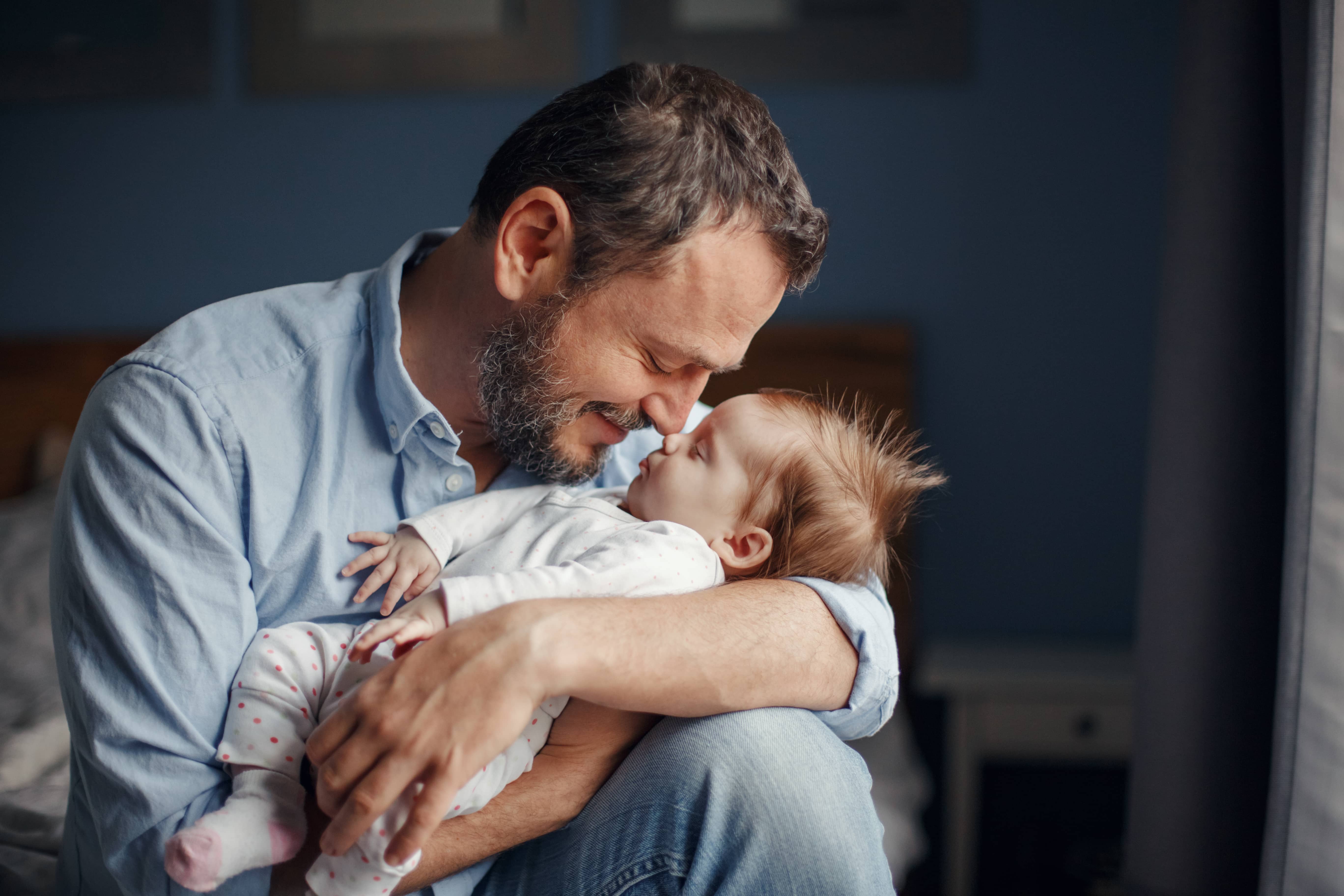 middleagecaucasianfatherkissingsleepingnewbornbabygirl-parent