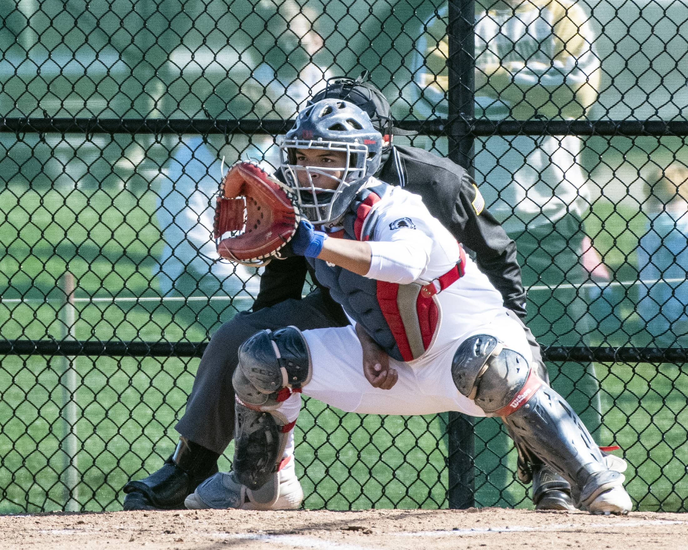 Brunswick School standout catcher Adonys Guzman preps for the ball during a recent game at Brunswick's baseball field.