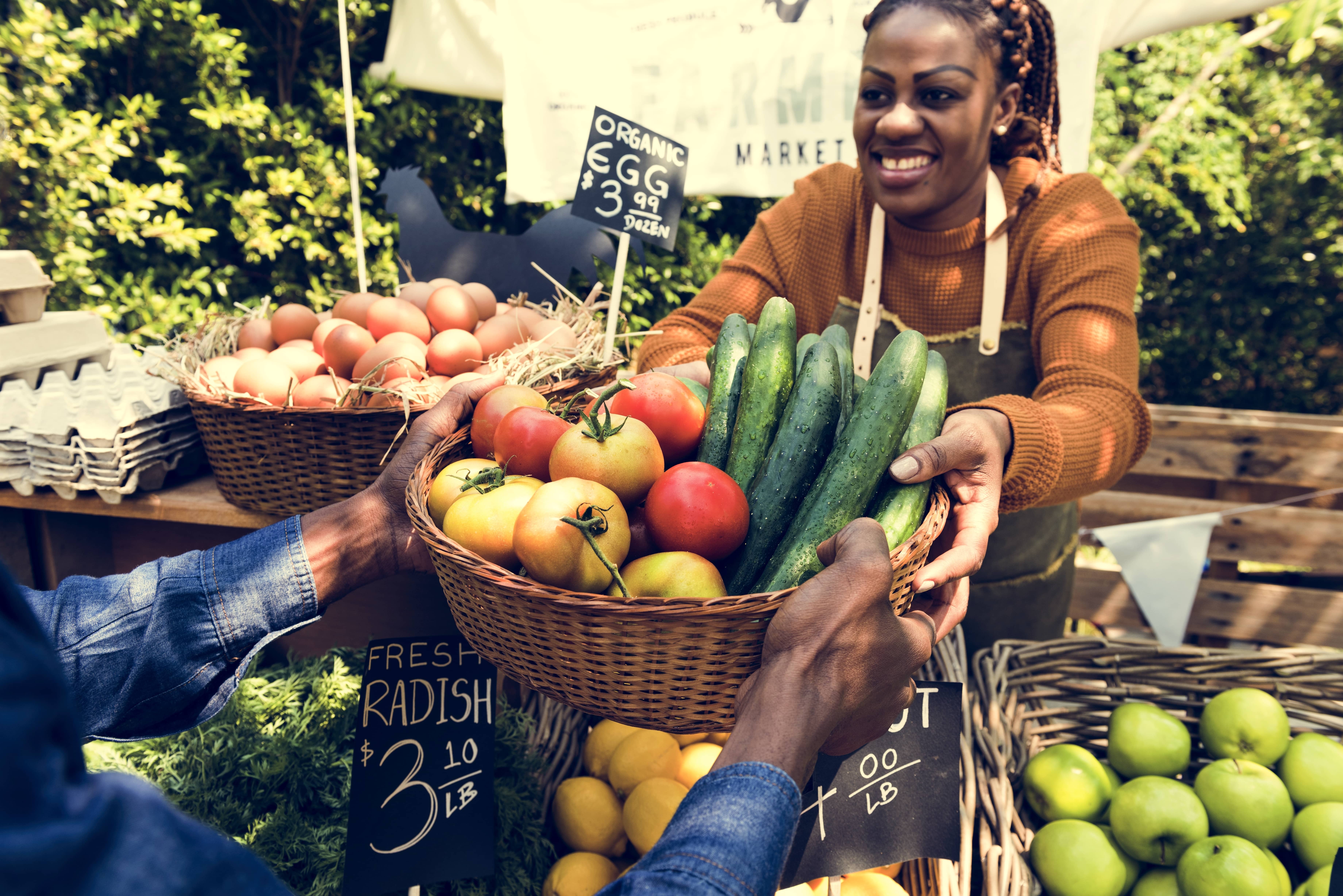 womansellingfreshlocalvegetableatfarmersmarket