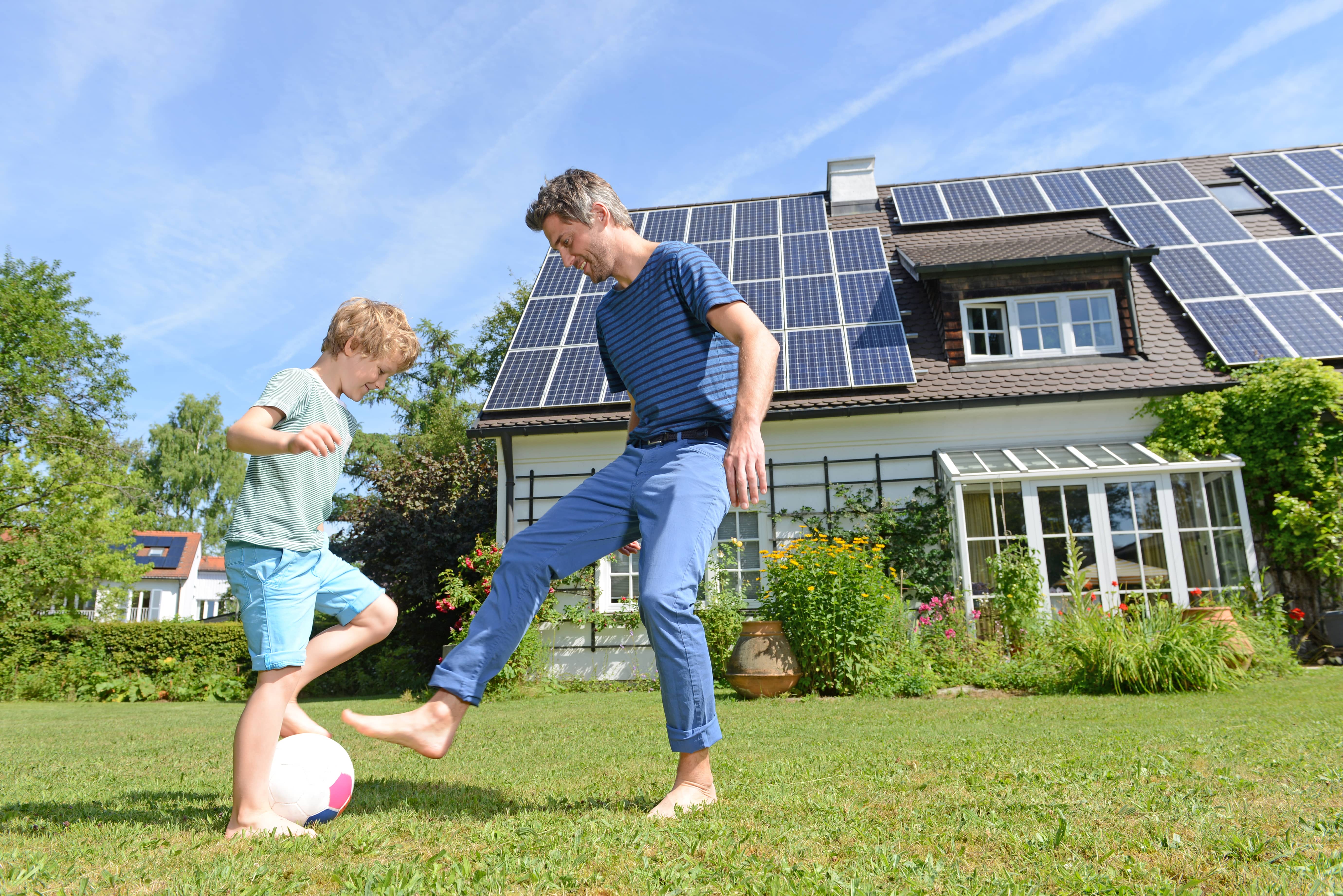fatherandsonplayingfootballingardenofsolarpaneled
