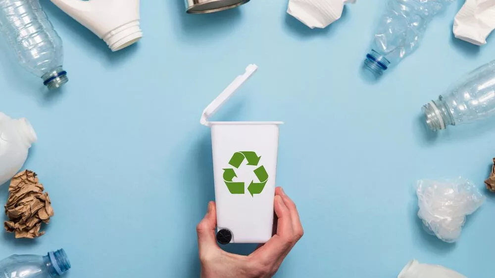 handholdingarecyclinggarbagebinwithlotsofwaste
