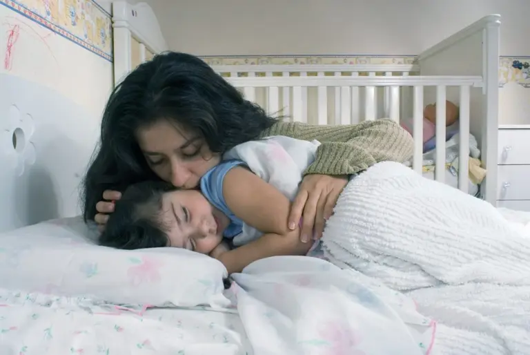 mothersayinggoodnightandtuckingherdaughterintobed