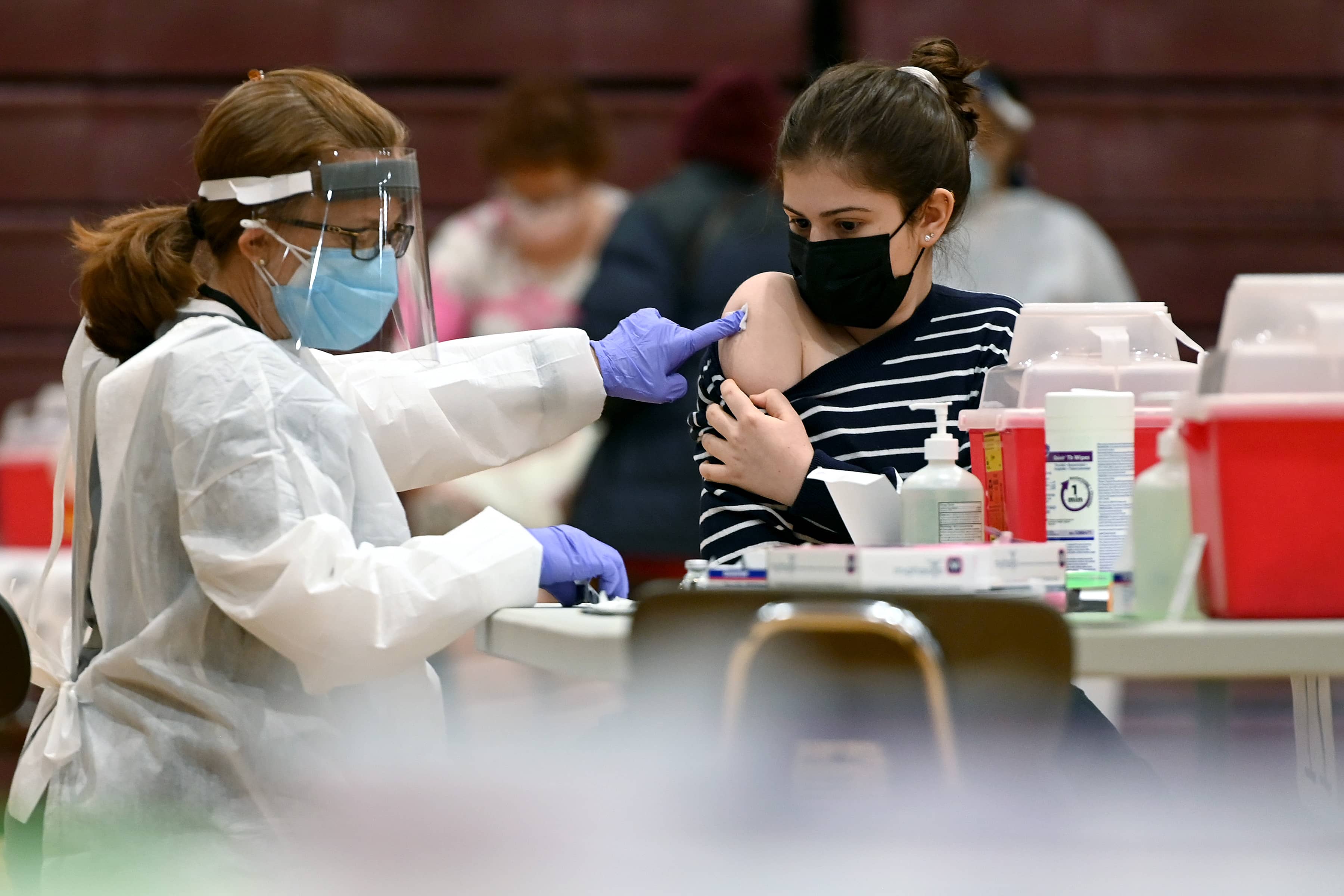 Nurse injecting a woman with COVID-19 vaccine