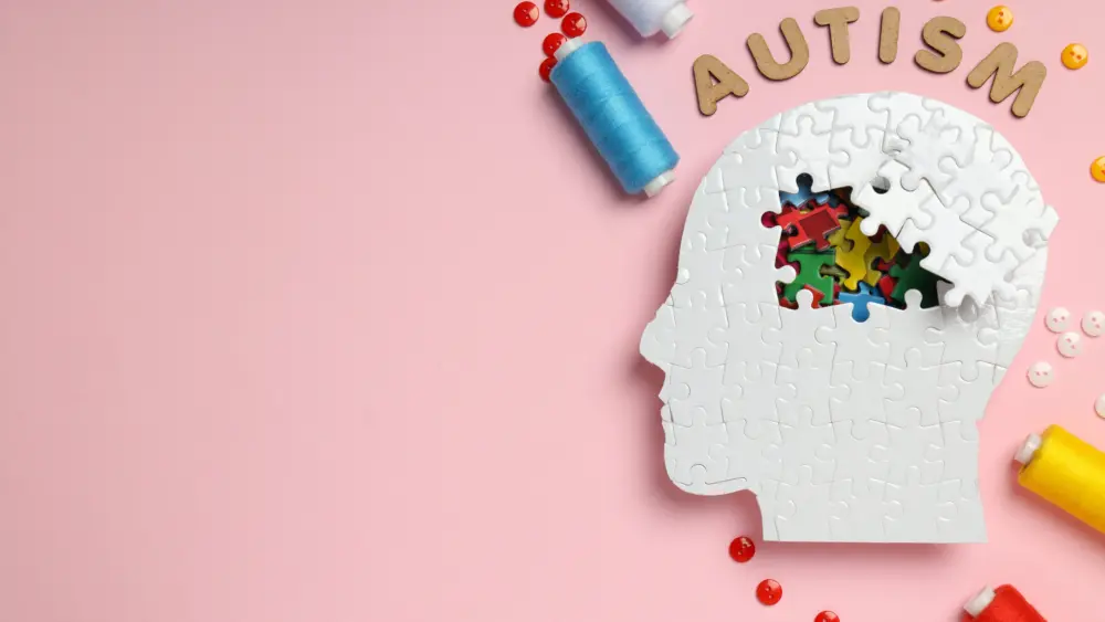 puzzle-head-word-autism-threads-and-buttons-on-pink-background