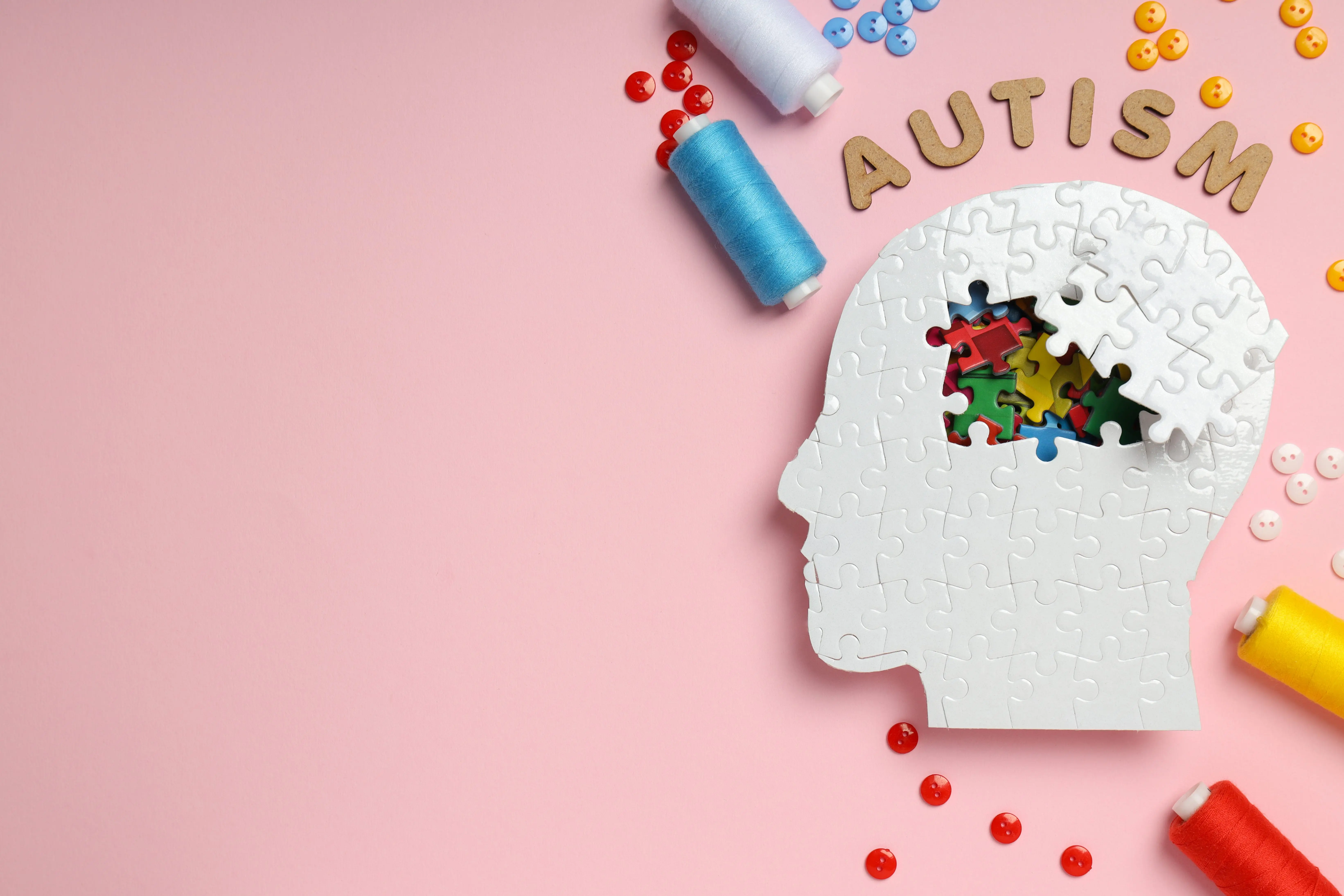 puzzle-head-word-autism-threads-and-buttons-on-pink-background