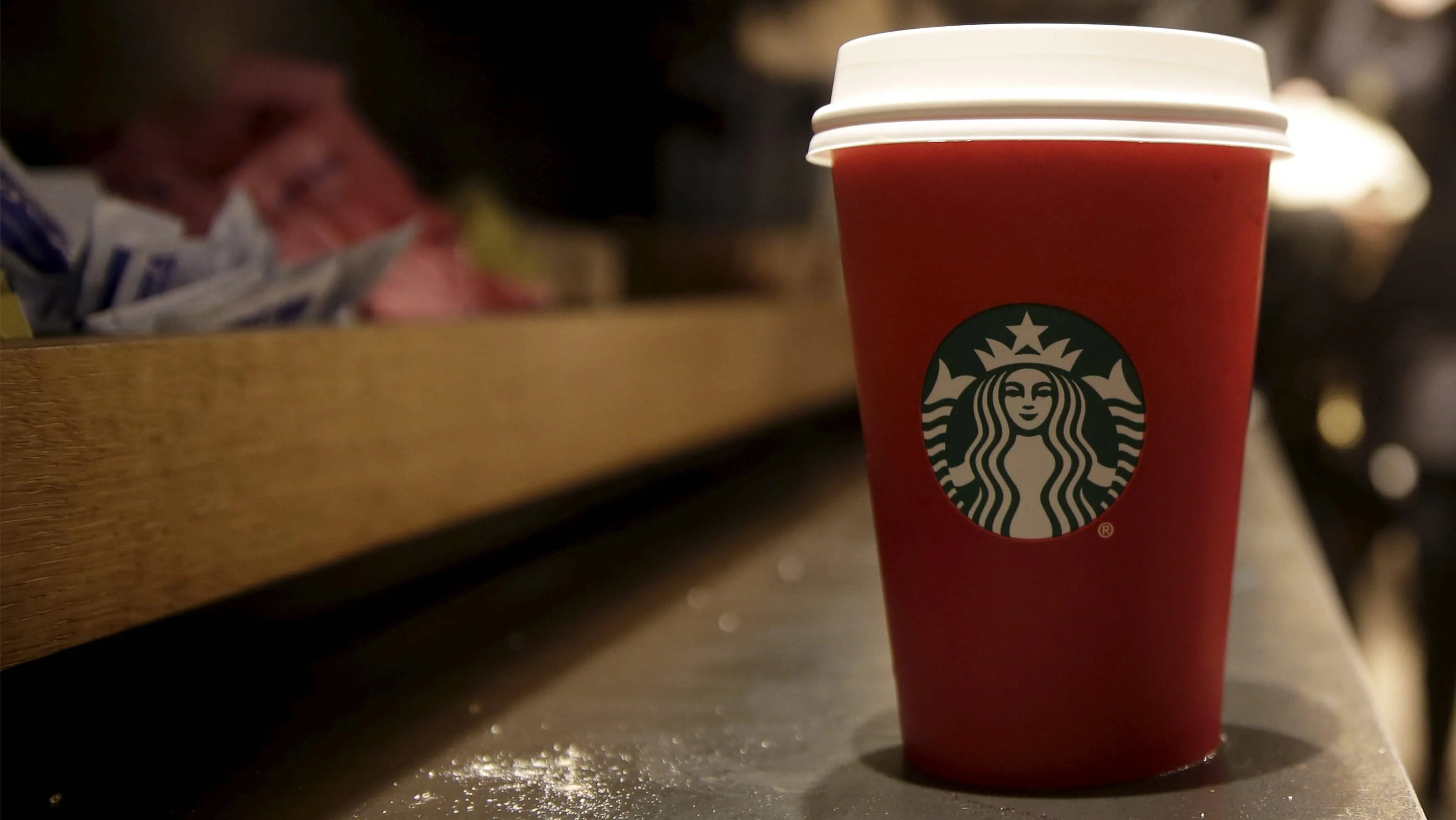 a-red-starbucks-cup-sits-on-the-counter-of-a-starbucks-in-new-york