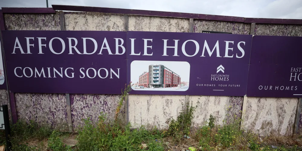 a-sign-advertising-affordable-housing-is-displayed-next-to-an-area-of-wasteland-in-liverpool