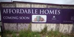 a-sign-advertising-affordable-housing-is-displayed-next-to-an-area-of-wasteland-in-liverpool
