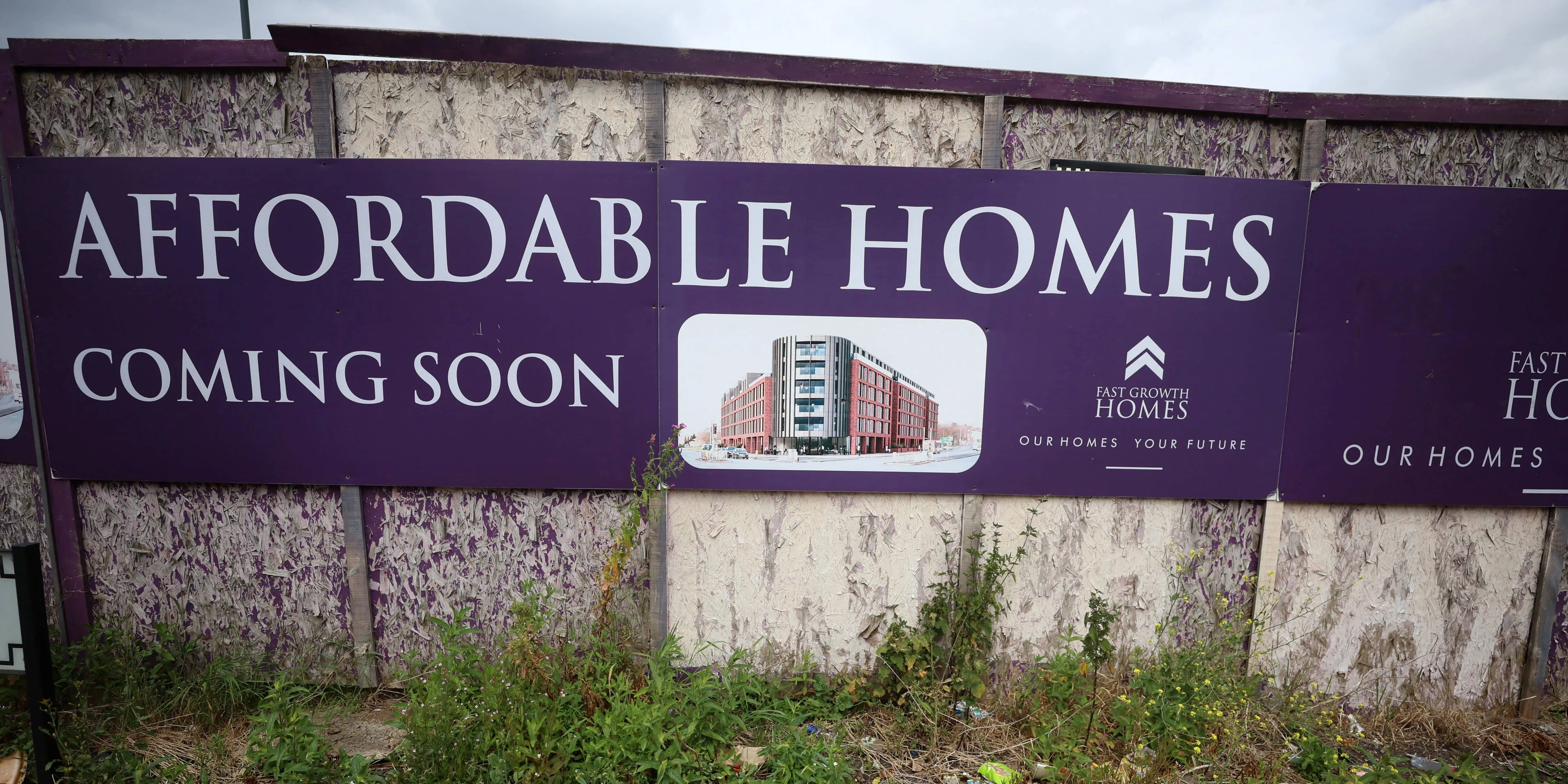 a-sign-advertising-affordable-housing-is-displayed-next-to-an-area-of-wasteland-in-liverpool