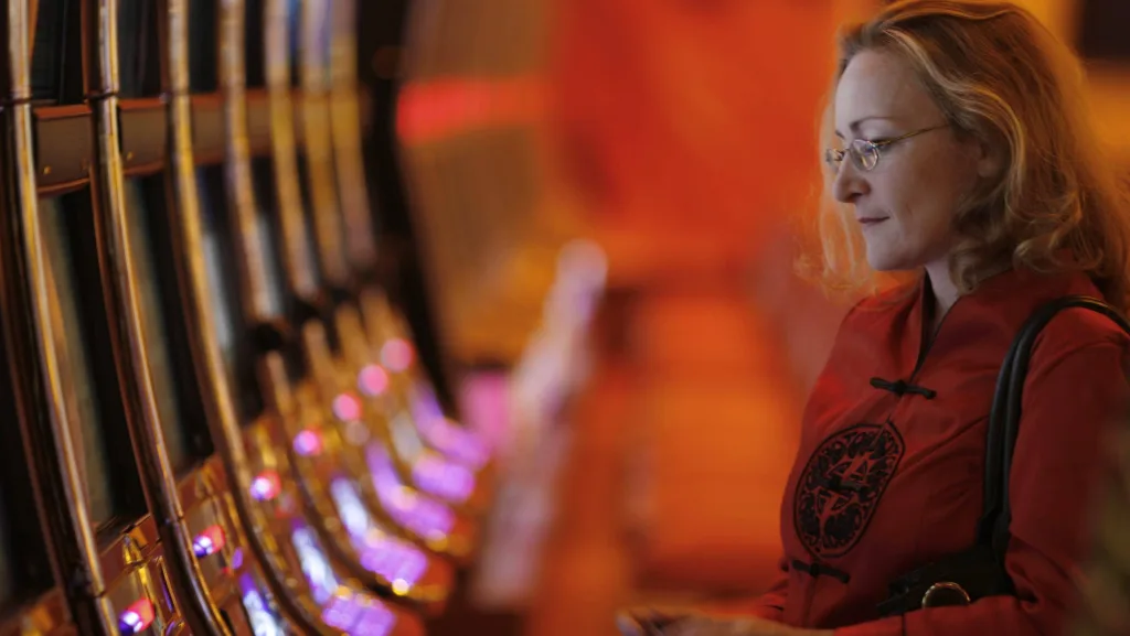 a-woman-looks-at-slots-machines-inside-the-resorts-world-sentosa-casino-on-singapores-sentosa-island