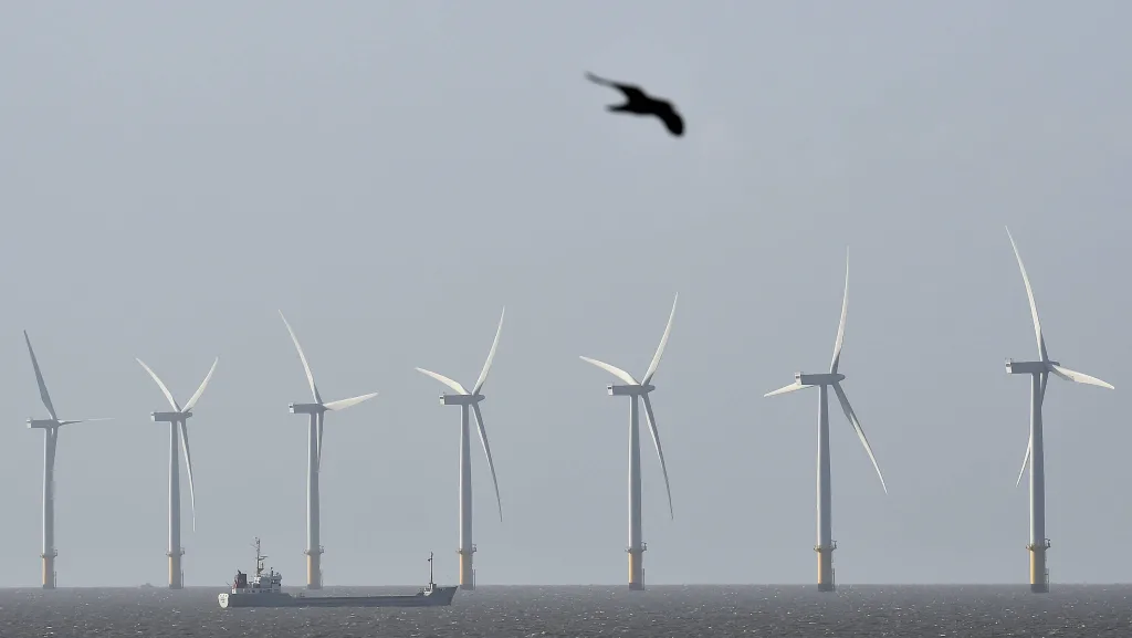 a-cargo-ship-passes-in-front-of-an-off-shore-wind-farm-in-the-english-channel-near-clacton-on-sea-in-south-east-england