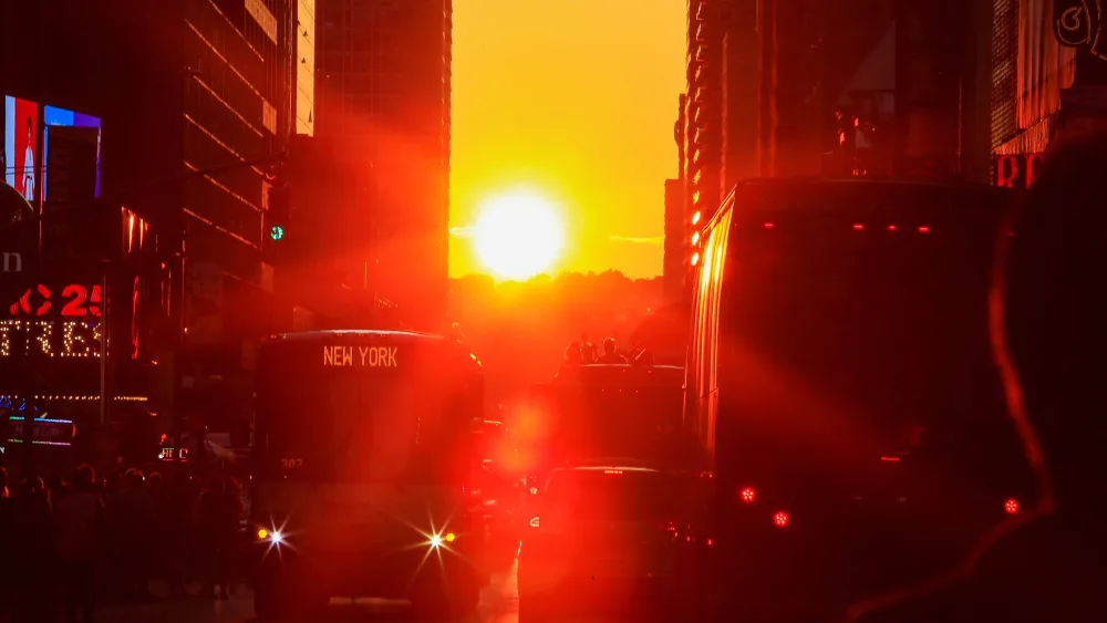 people-watch-the-sun-sets-over-manhattan-aligned-exactly-with-the-streets-in-a-phenomenon-known-as-manhattanhenge-in-times-square-in-new-york