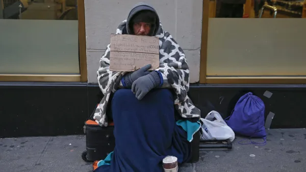 a-man-holding-up-a-sign-stating-he-is-homeless-hungry-and-cold-sits-along-7th-avenue-in-new-york