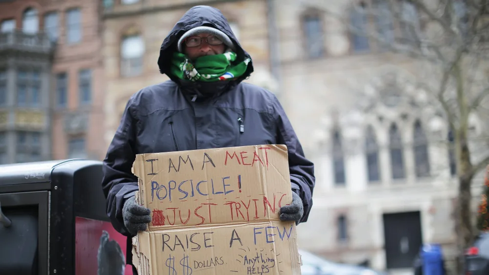 james-tocchio-who-is-homeless-holds-up-a-sign-as-cold-temperatures-hit-boston-massachusetts