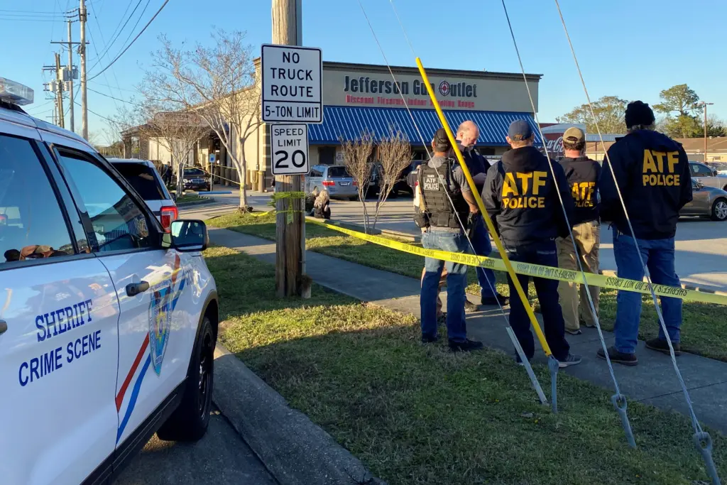 law-enforcement-officers-stand-near-the-site-of-a-shooting-at-a-gun-store-in-metairie