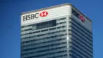 file-photo-hsbcs-building-in-canary-wharf-is-seen-behind-a-city-of-london-sign-outside-billingsgate-market-in-london