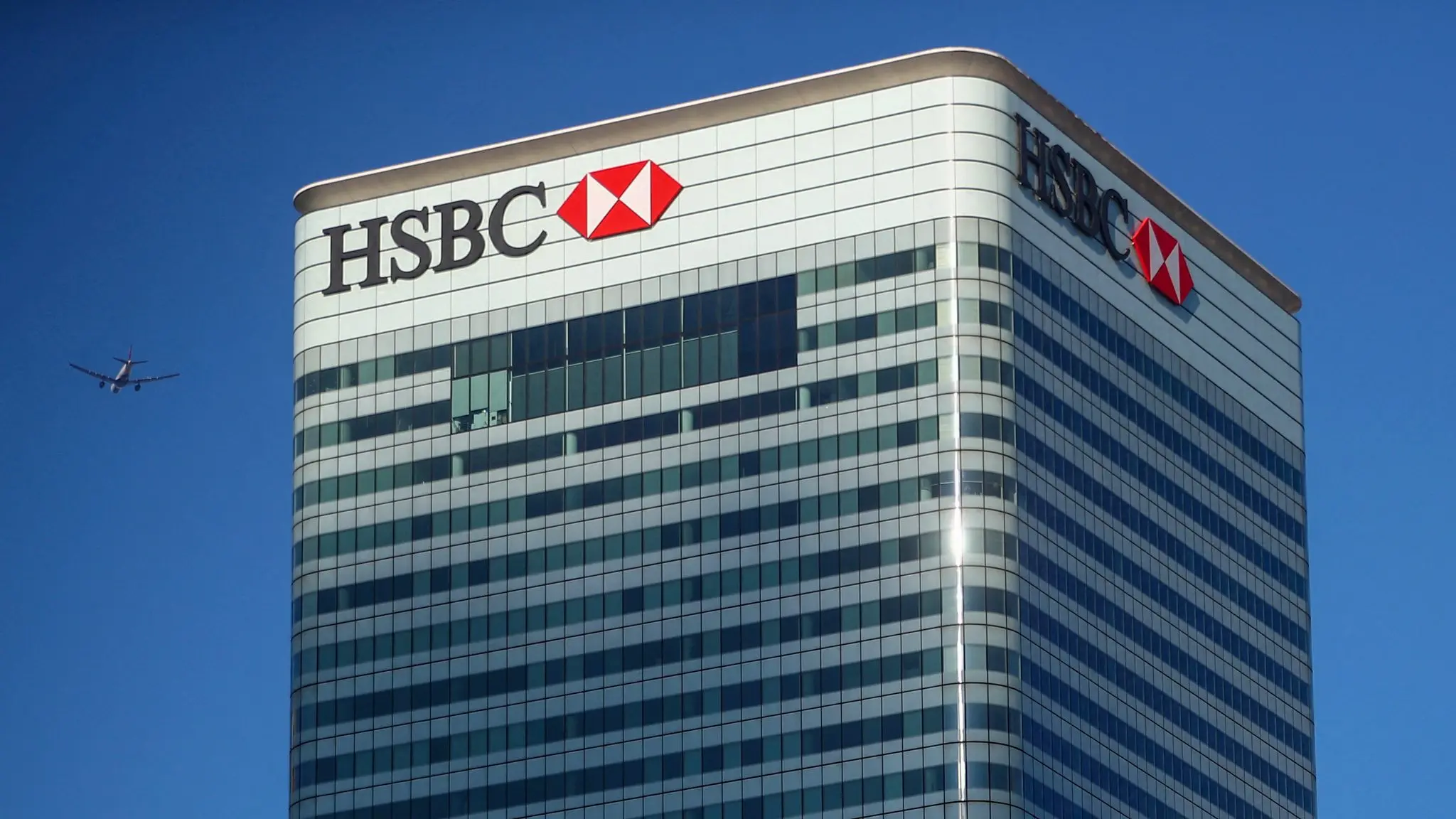 file-photo-hsbcs-building-in-canary-wharf-is-seen-behind-a-city-of-london-sign-outside-billingsgate-market-in-london