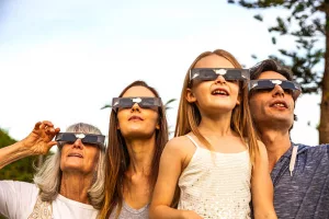family-looking-at-solar-eclipse-using-solar-glasses