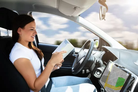 young-woman-looking-at-diary-while-sitting-in-self-driving-modern-car